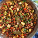 cuban Picadillo in a skillet with a lime.