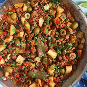 cuban Picadillo in a skillet with a lime.