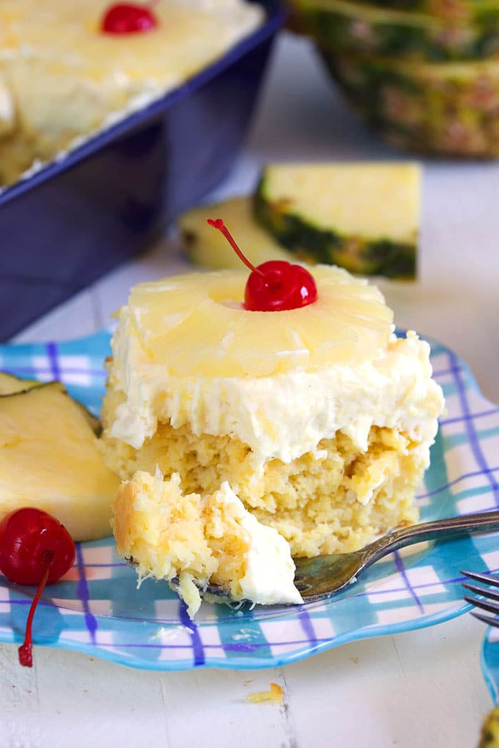 Pineapple sunshine cake with a fork that has a bite on it.