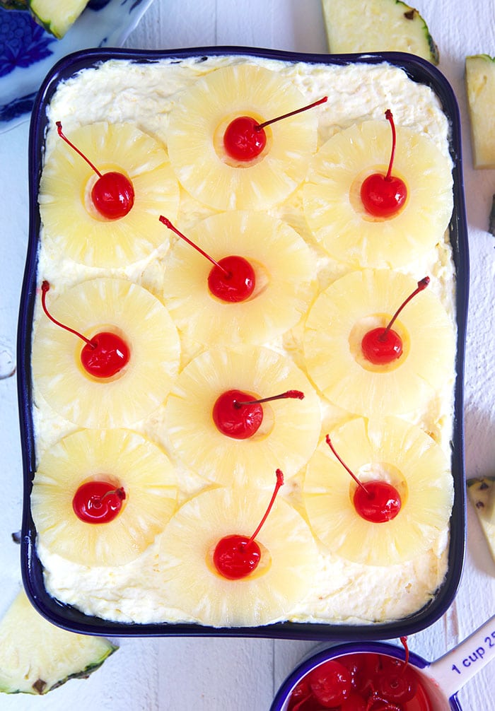 Overhead shot of pineapple sunshine cake in a blue baking dish.