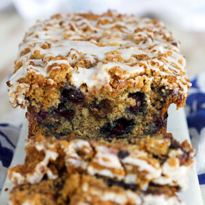 Blueberry Banana Bread with streusel and glaze on a white marble board