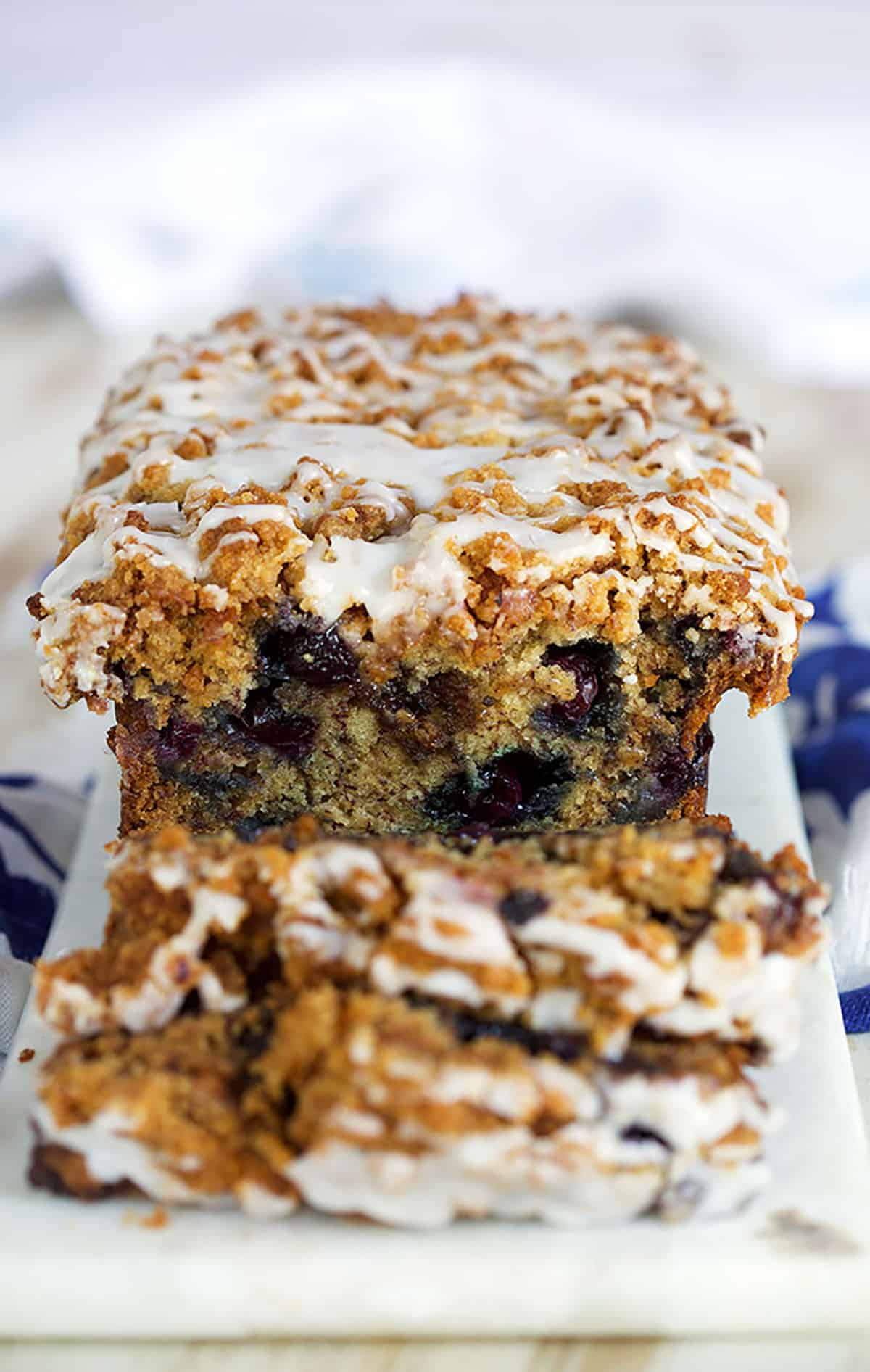 Blueberry Banana Bread with streusel and glaze on a white marble board 