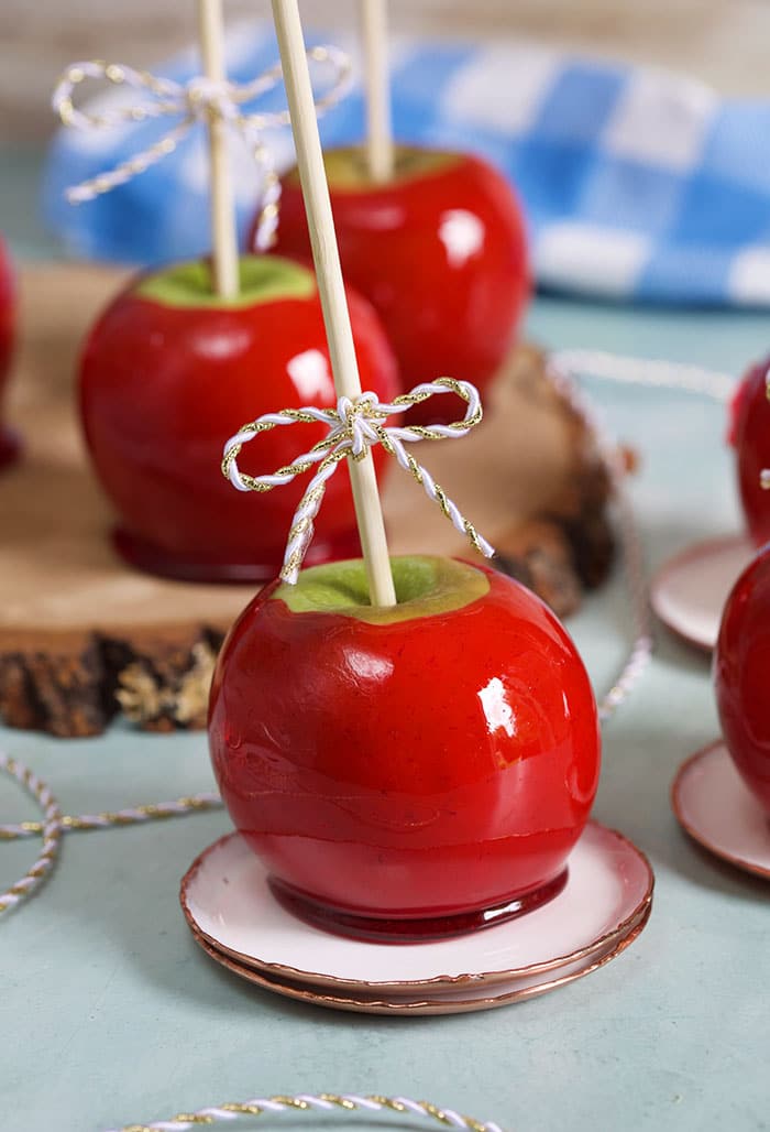Candy apples on a wood slice on a blue background.