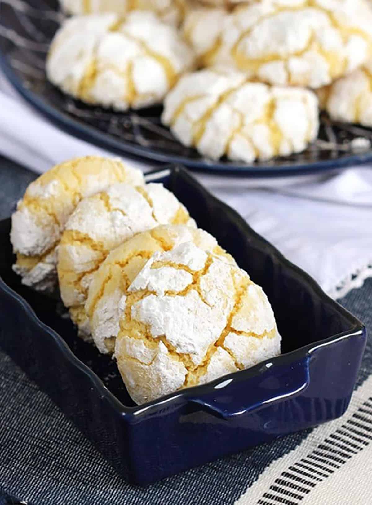 Gooey Butter Cookies in a blue dish on a blue and white tablecloth