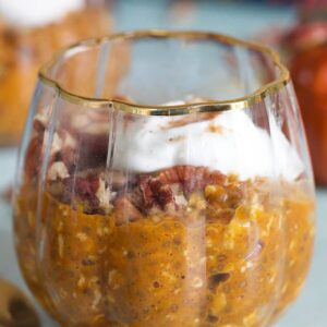 close up of pumpkin oats in a glass with a gold spoon.
