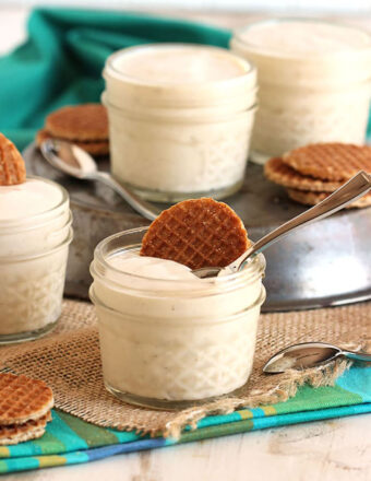 Vanilla Pudding in a small glass jar with a mini stroopwafel on top. Jar is placed on a small piece of burlap.