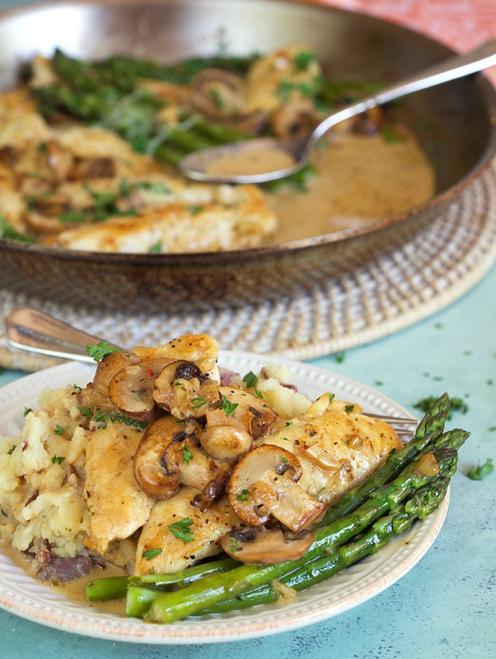 Chicken Madeira on a plate with asparagus.
