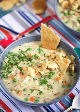 Blue bowl with chicken pot pie soup that was made in the crock pot or slow cooker.