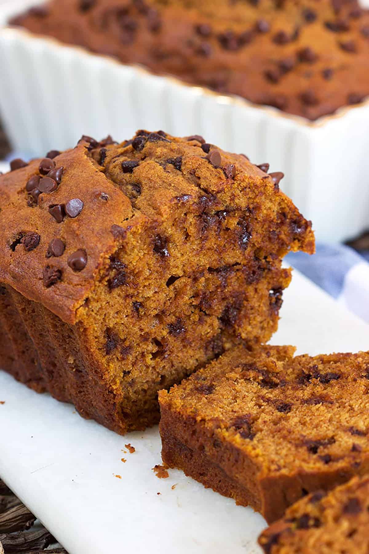 Chocolate Chip Pumpkin Bread loaf sliced on a white board.