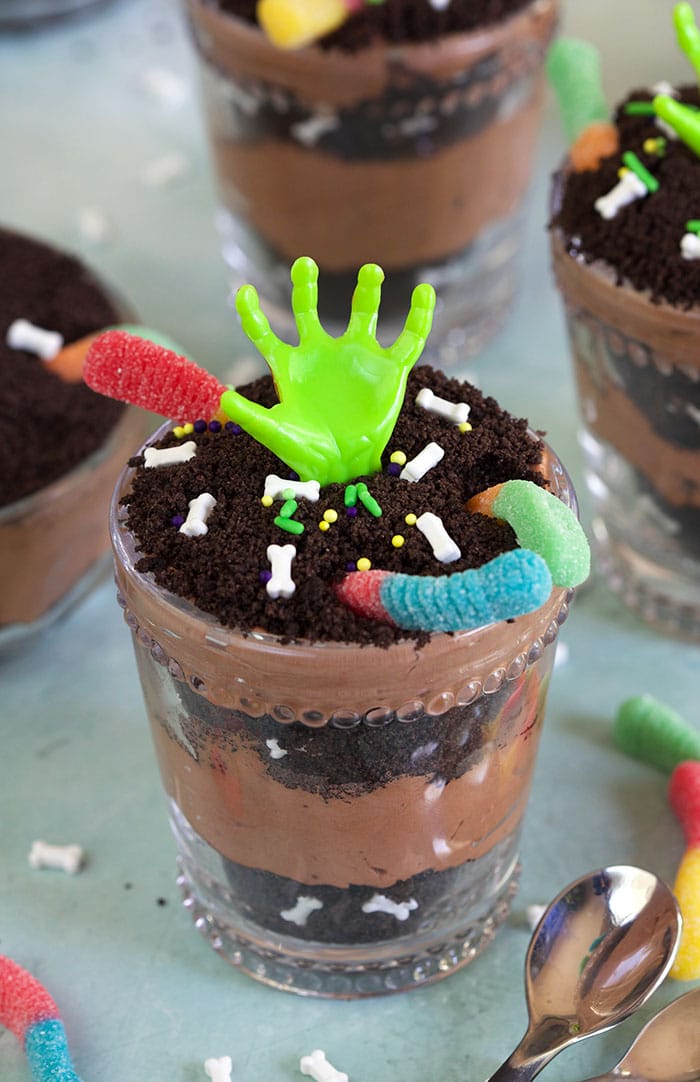 Dirt pudding cup with a zombie hand and gummy worms.