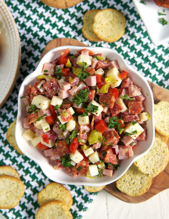 Hoagie dip in a white bowl with crostini around it.