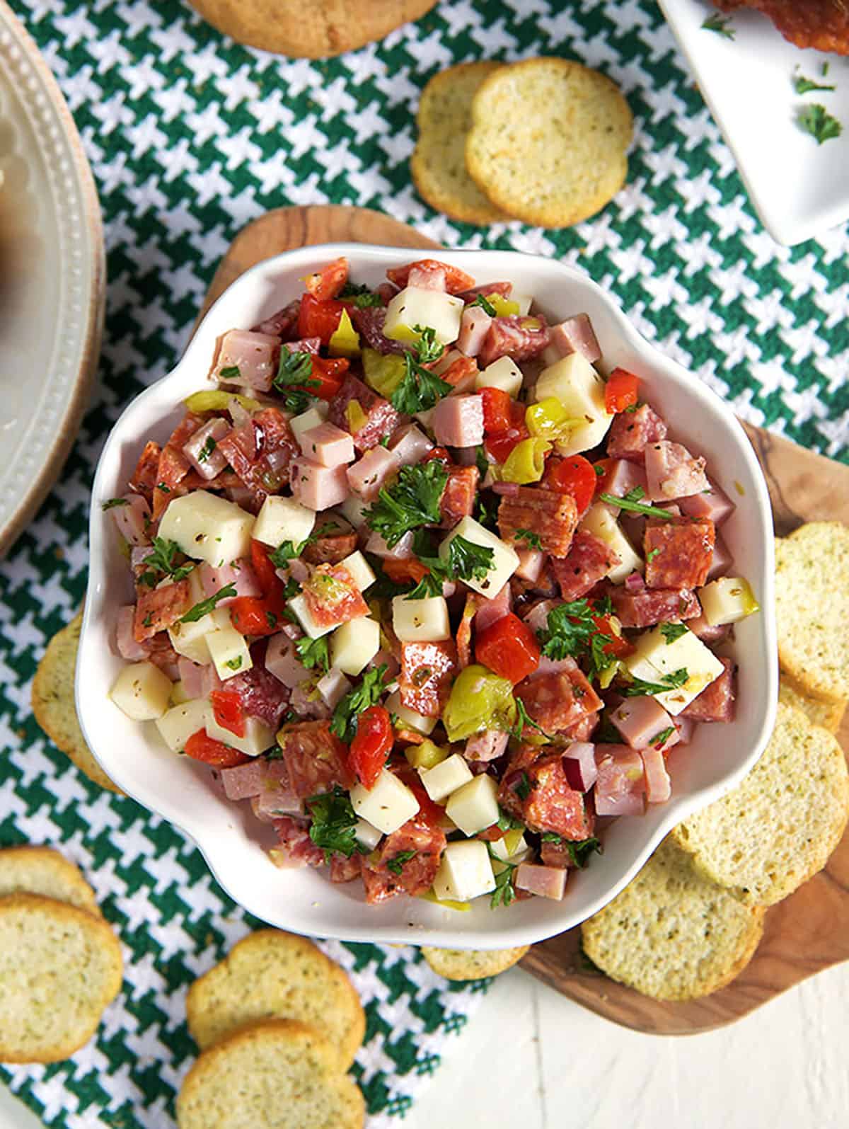 Hoagie dip in a white bowl with crostini around it.