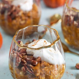 Pumpkin Overnight Oats in a pumpkin glass with greek yogurt on top.