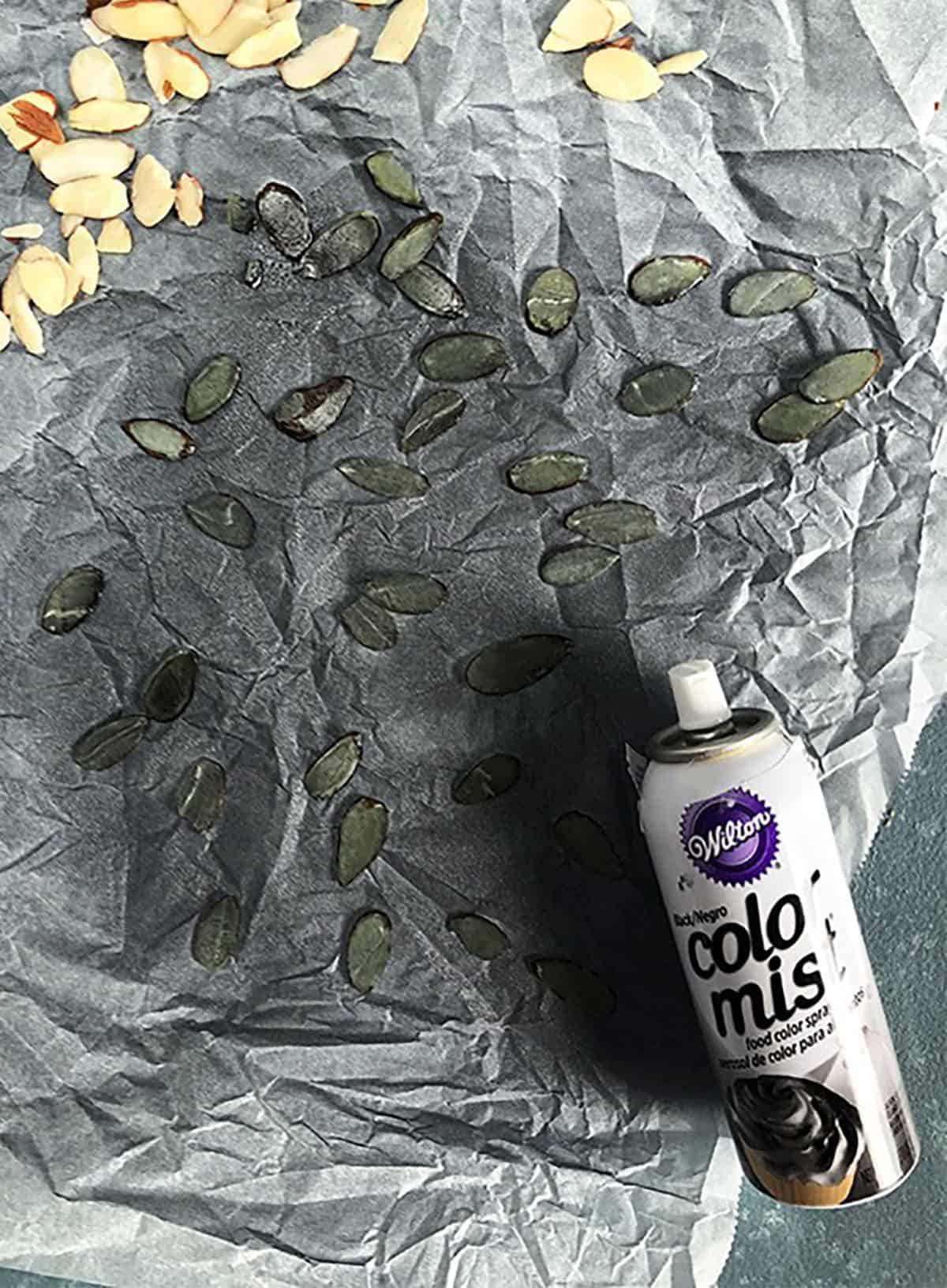 Almond slivers being colored black with Wilton Color Mist