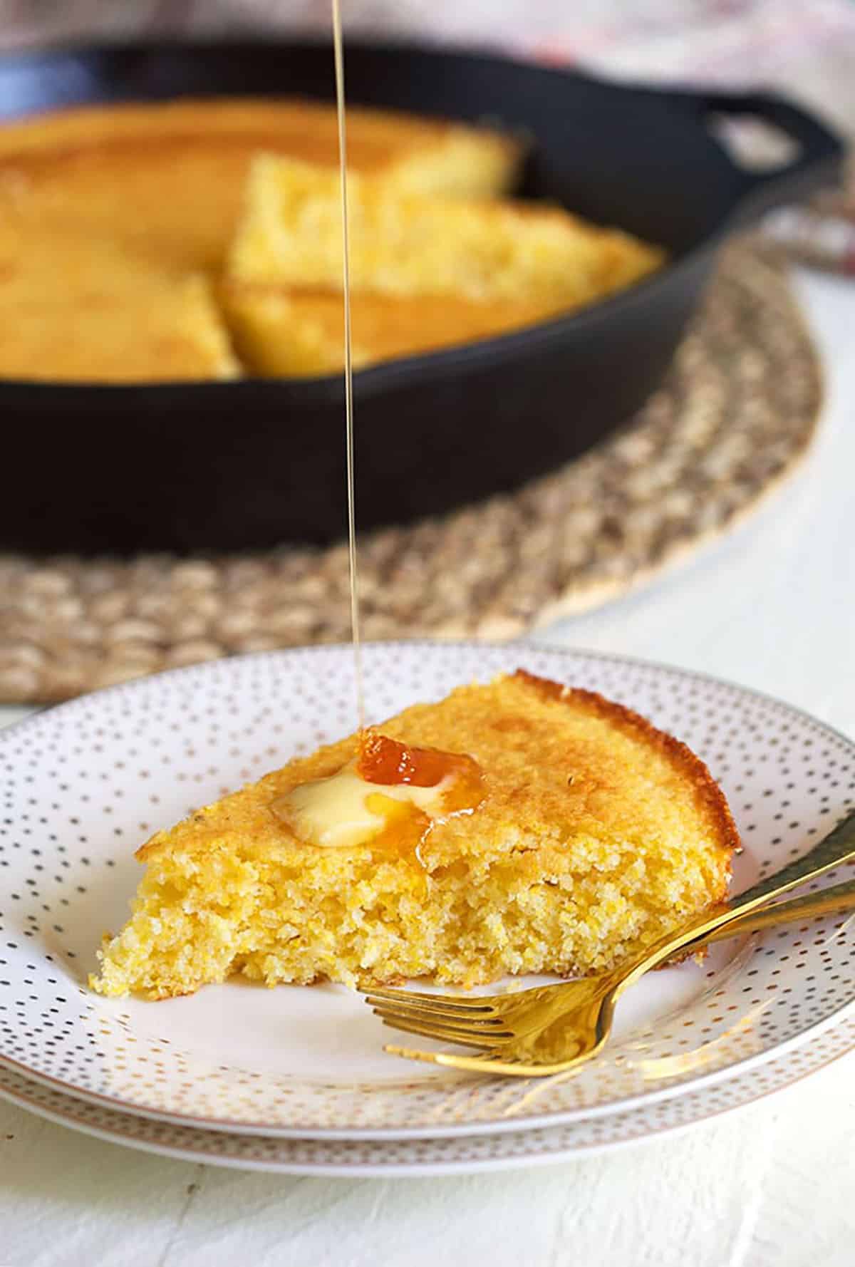 Honey is drizzled onto a piece of cornbread.