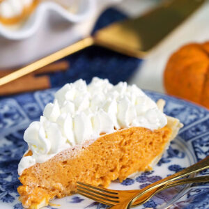 Slice of Pumpkin chiffon pie on a blue and white plate.