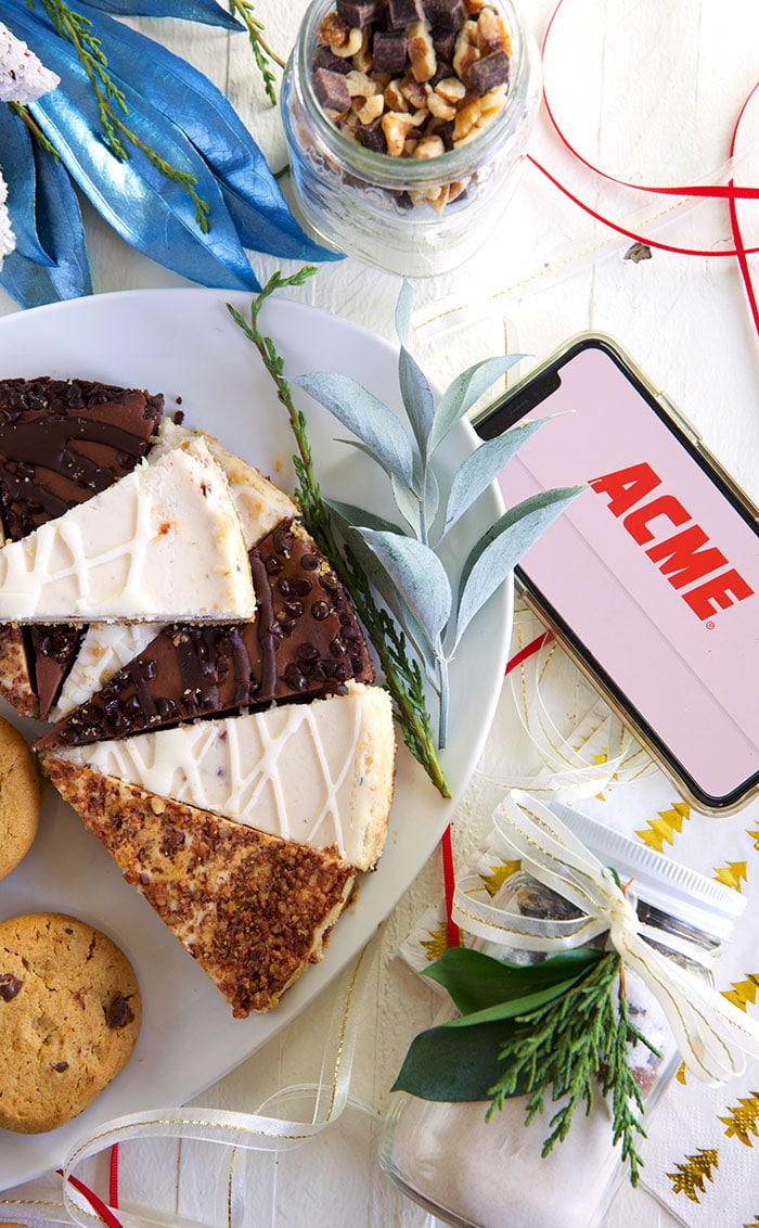 cheesecake on a white platter with an iPhone with the ACME logo 