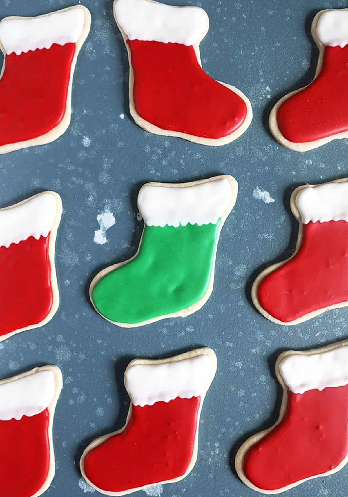 Red stocking cookies arranged in a line on a blue background.