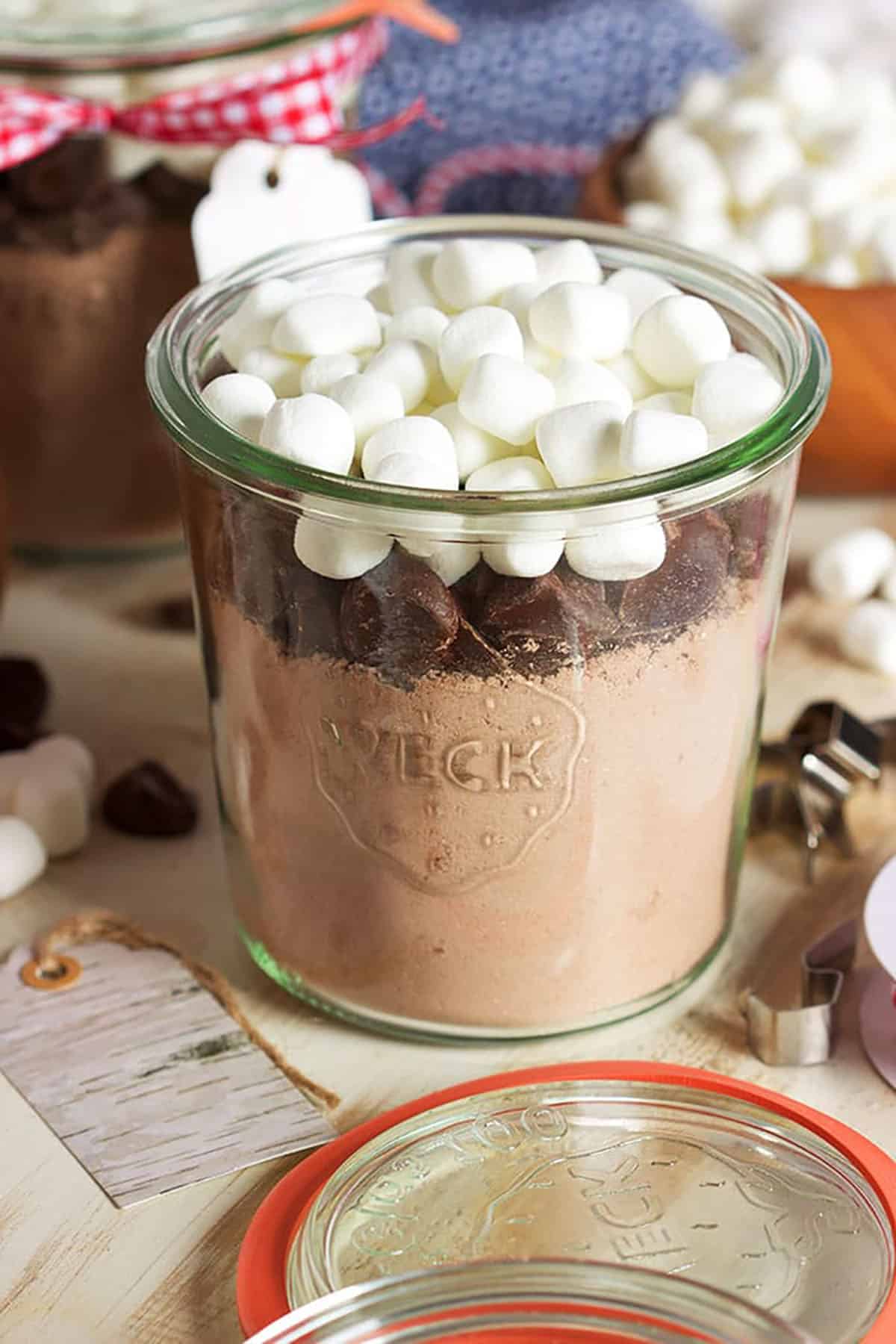Hot Cocoa mix in a Weck jar with chocolate chunks and mini marshmallows on top.