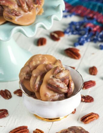 Praline Pecans in a white dish on a white background.