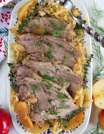 pork and sauerkraut on a platter on a white background.