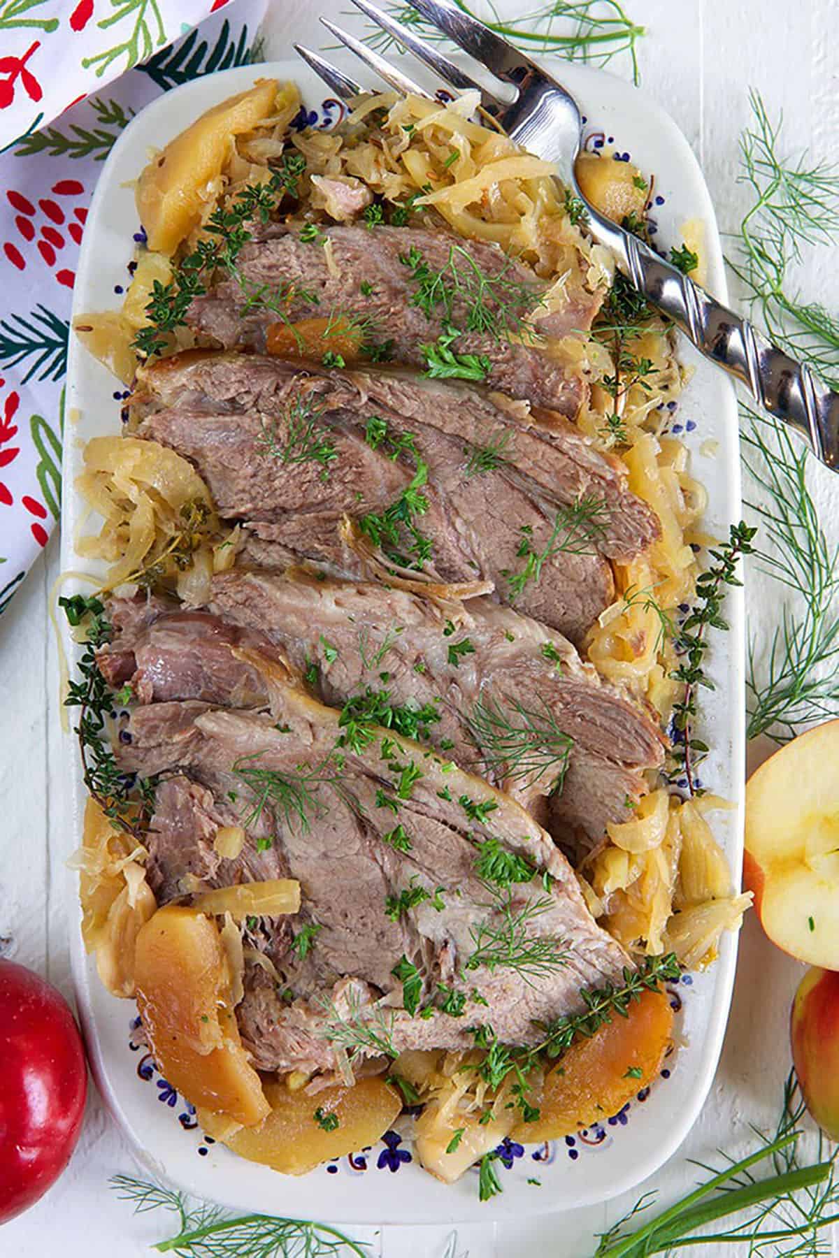 pork and sauerkraut on a platter on a white background.