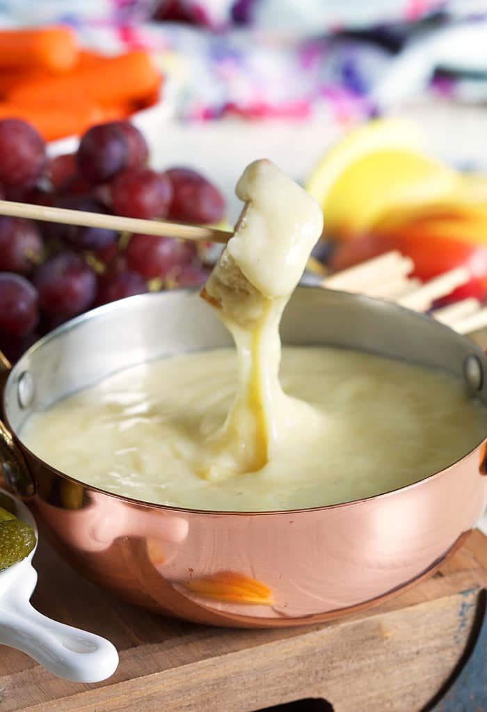 Bread being dipped into cheese fondue.