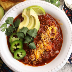 Best chili recipe in bowl with avocado, cilantro, cheese, and jalapeño