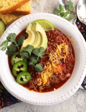 Best chili recipe in bowl with avocado, cilantro, cheese, and jalapeño