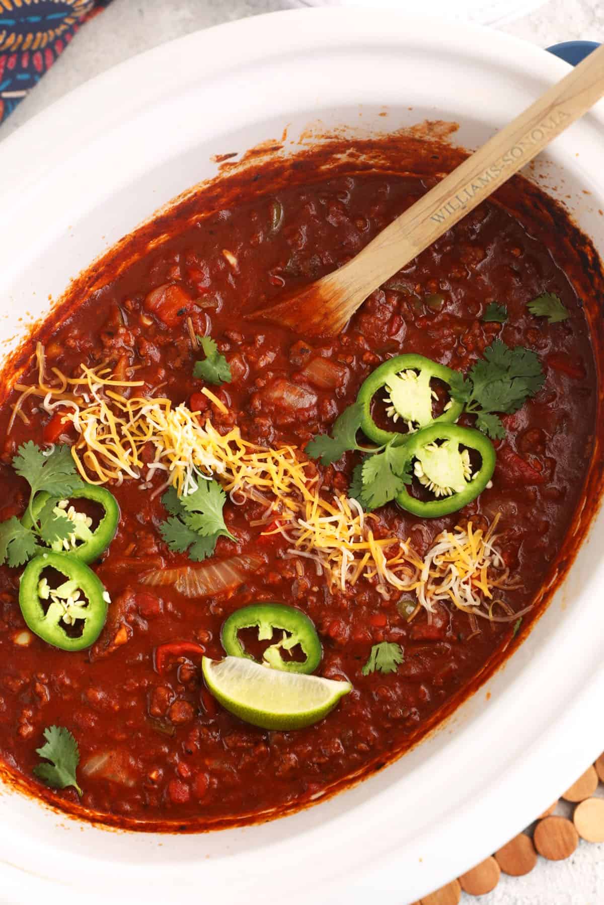 Overhead view of the best chili recipe in slow cooker with garnishes