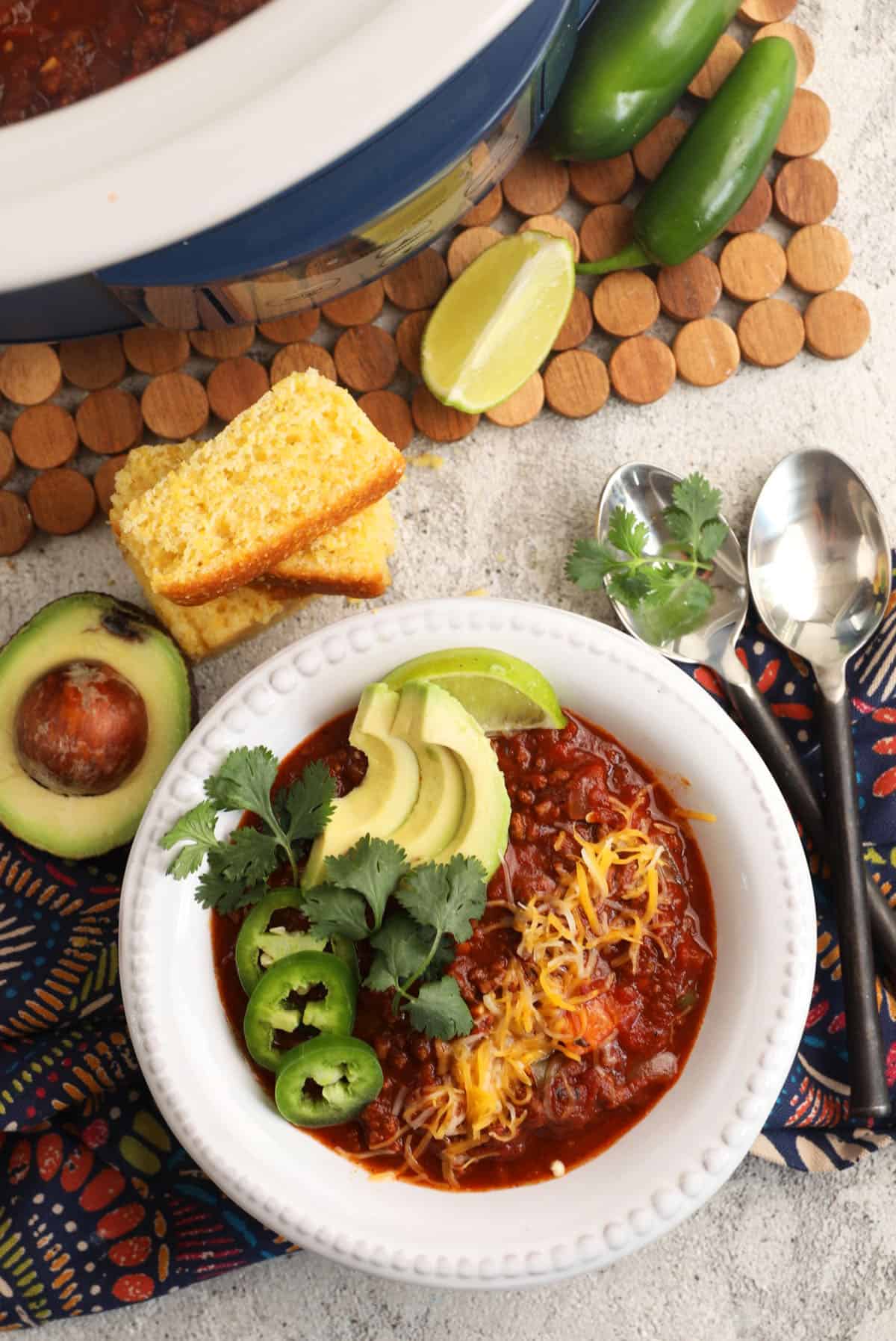 Best chili recipe in bowl with accompaniments on tabletop