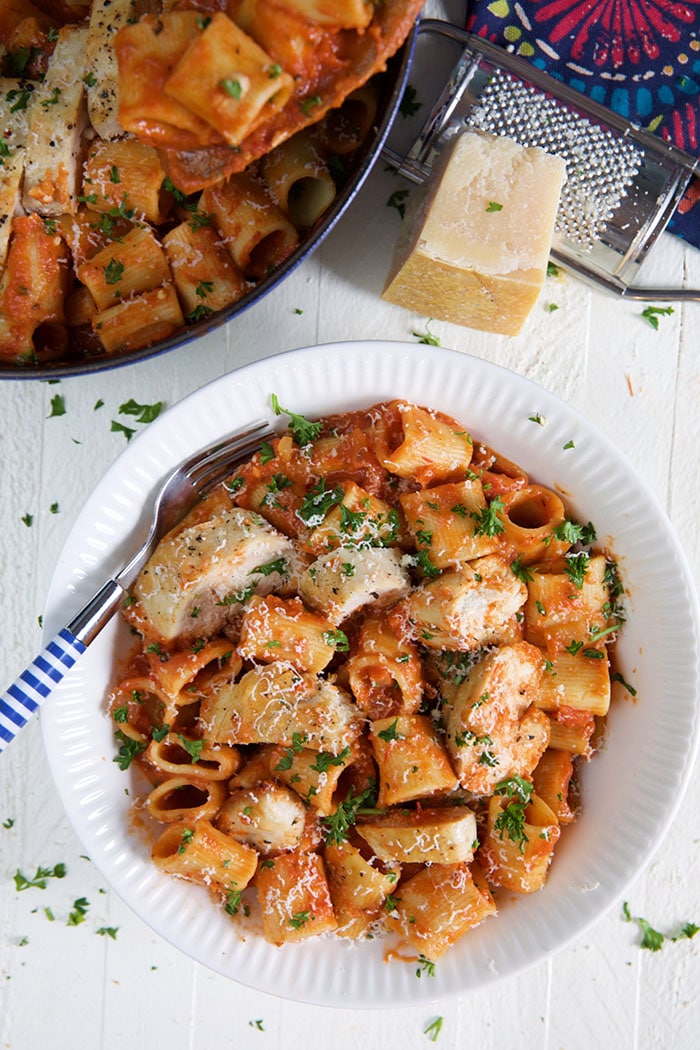 A serving of spicy chicken rigatoni is in a white bowl.