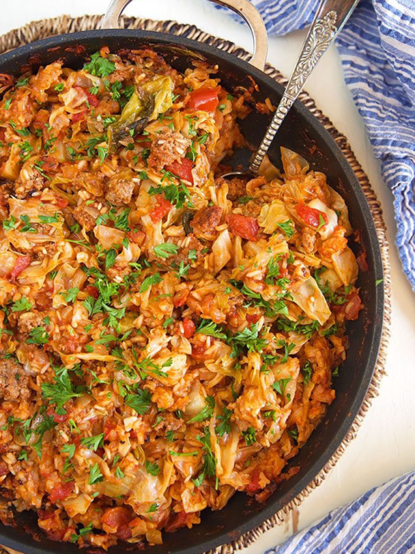 Overhead shot of stuffed cabbage casserole in a black skillet.