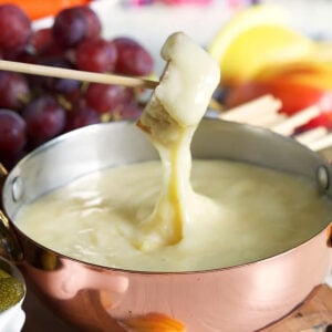 Bread being dipped into cheese fondue.