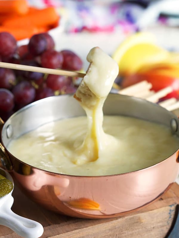 Bread being dipped into cheese fondue.