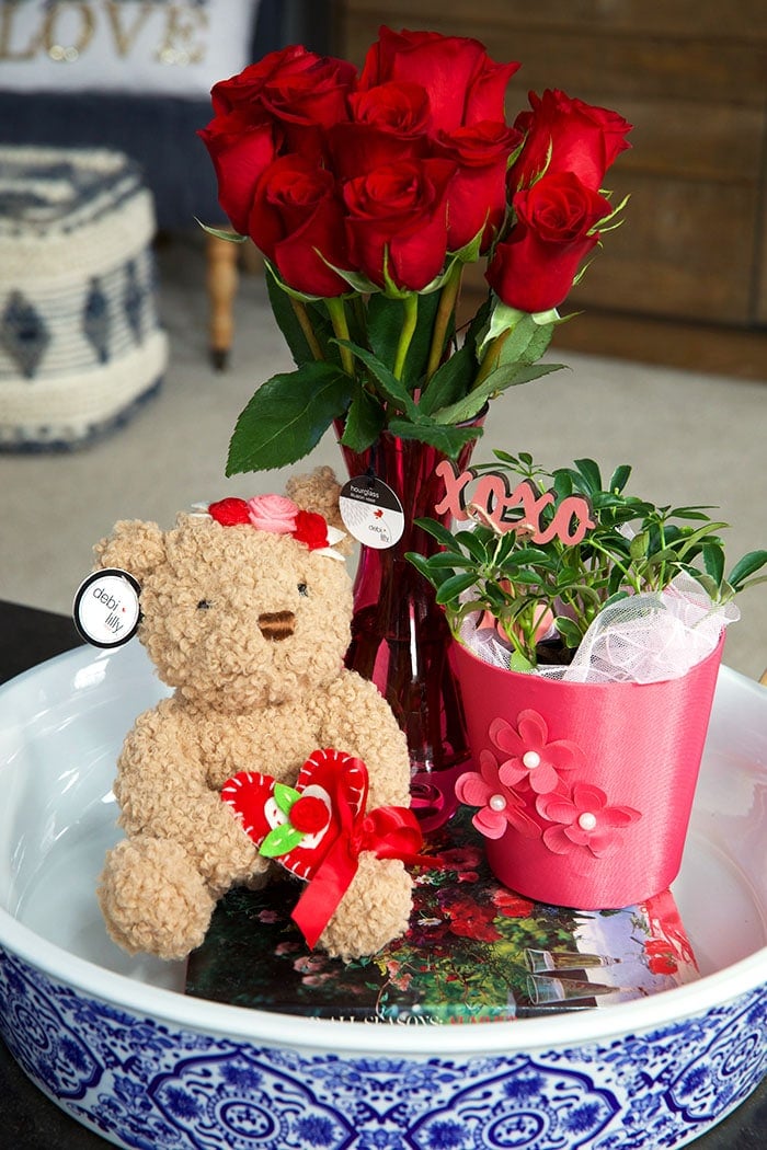teddy bear and roses in a blue and white ceramic tray.