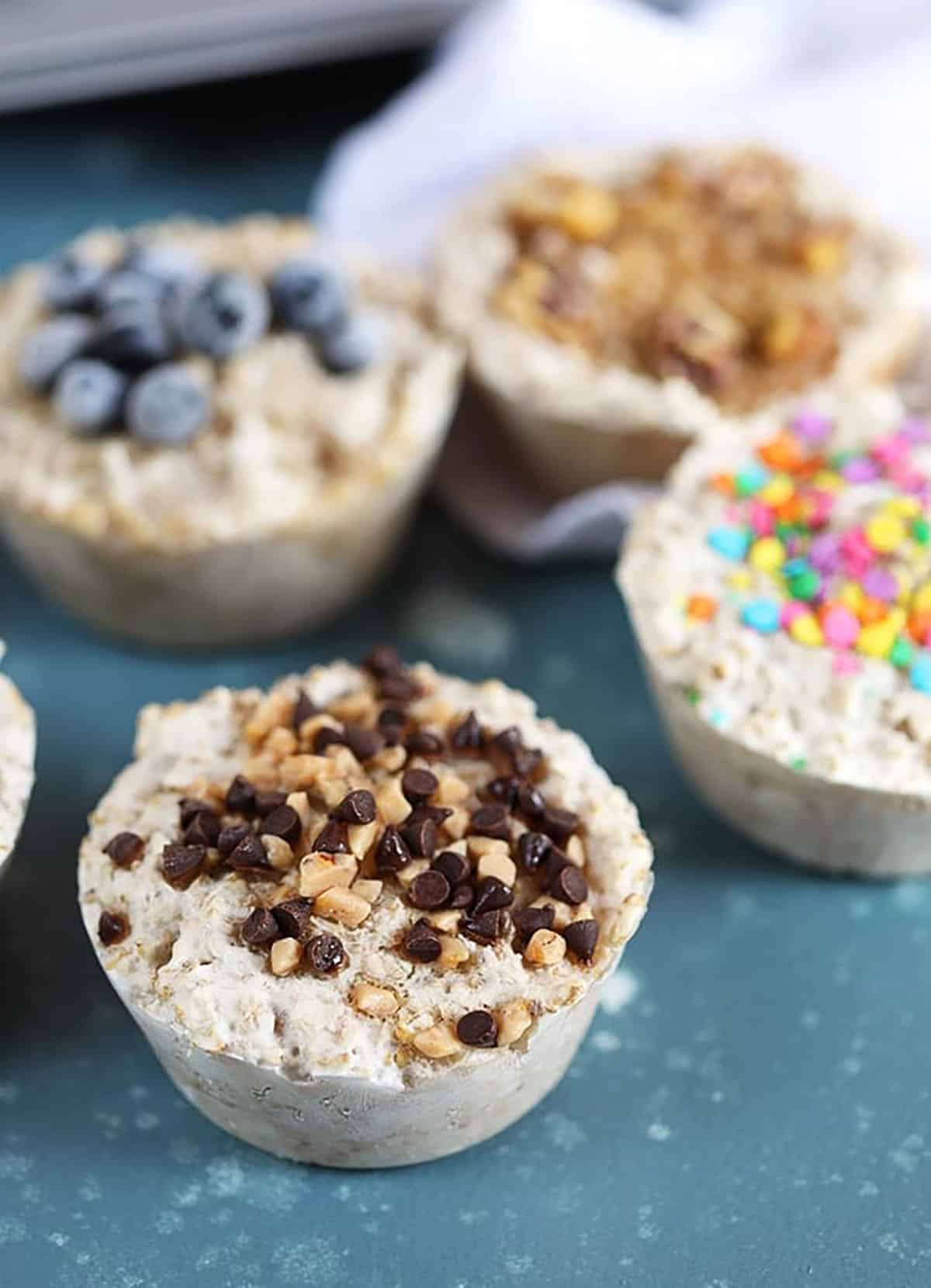 Freezer Steel Cut Oatmeal in muffin cups with toppings like blueberries, sprinkles and chocolate