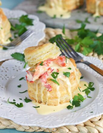 Lobster Newburg in a puff pastry shell on a white plate.
