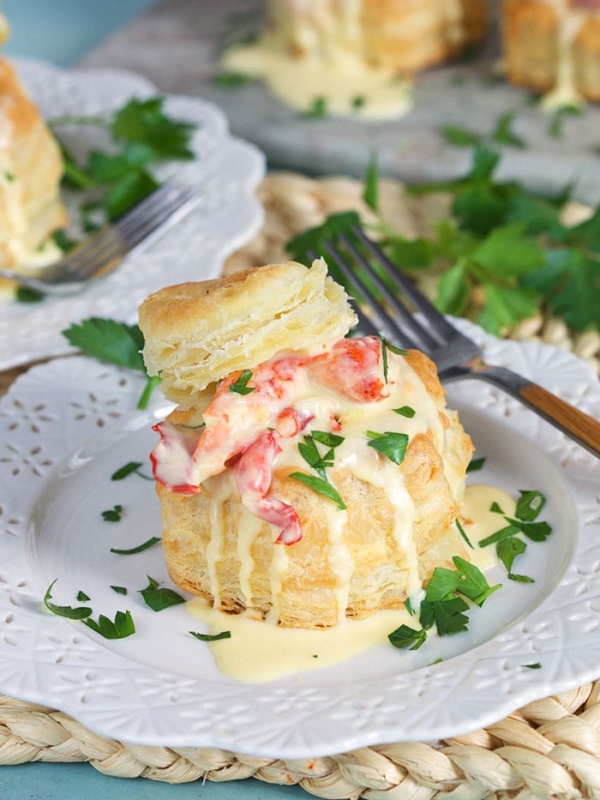 Lobster Newburg in a puff pastry shell on a white plate.