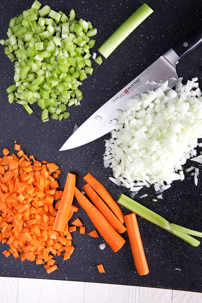 The chopped vegetables are in three neat piles on a black surface.