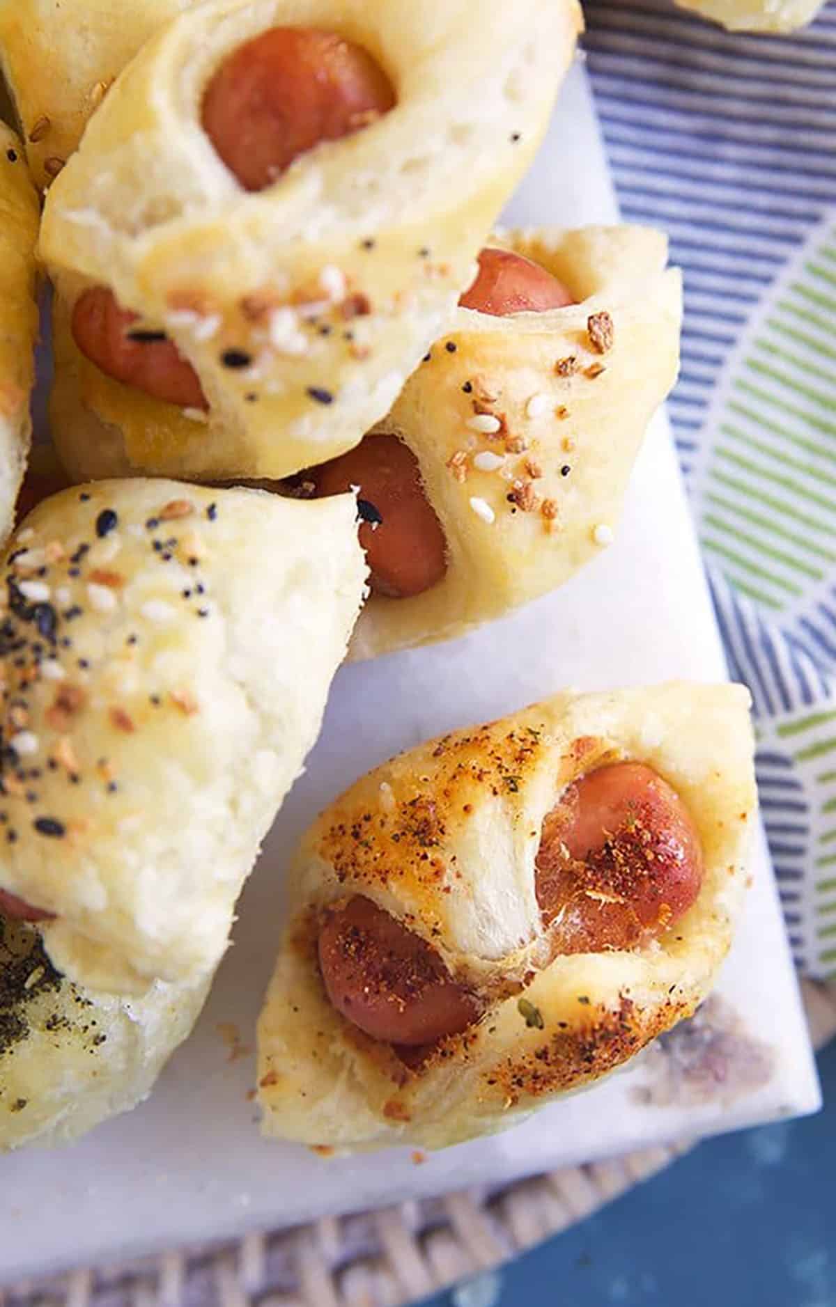 Pigs in a Blanket with Peri Peri seasoning on a white marble board.