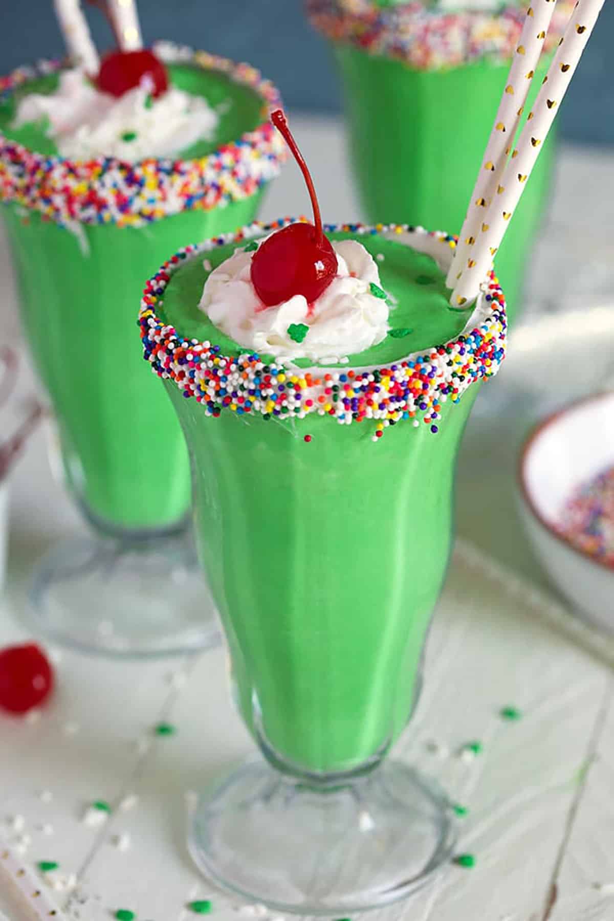 close up of shamrock shake in a glass with sprinkles on the rim