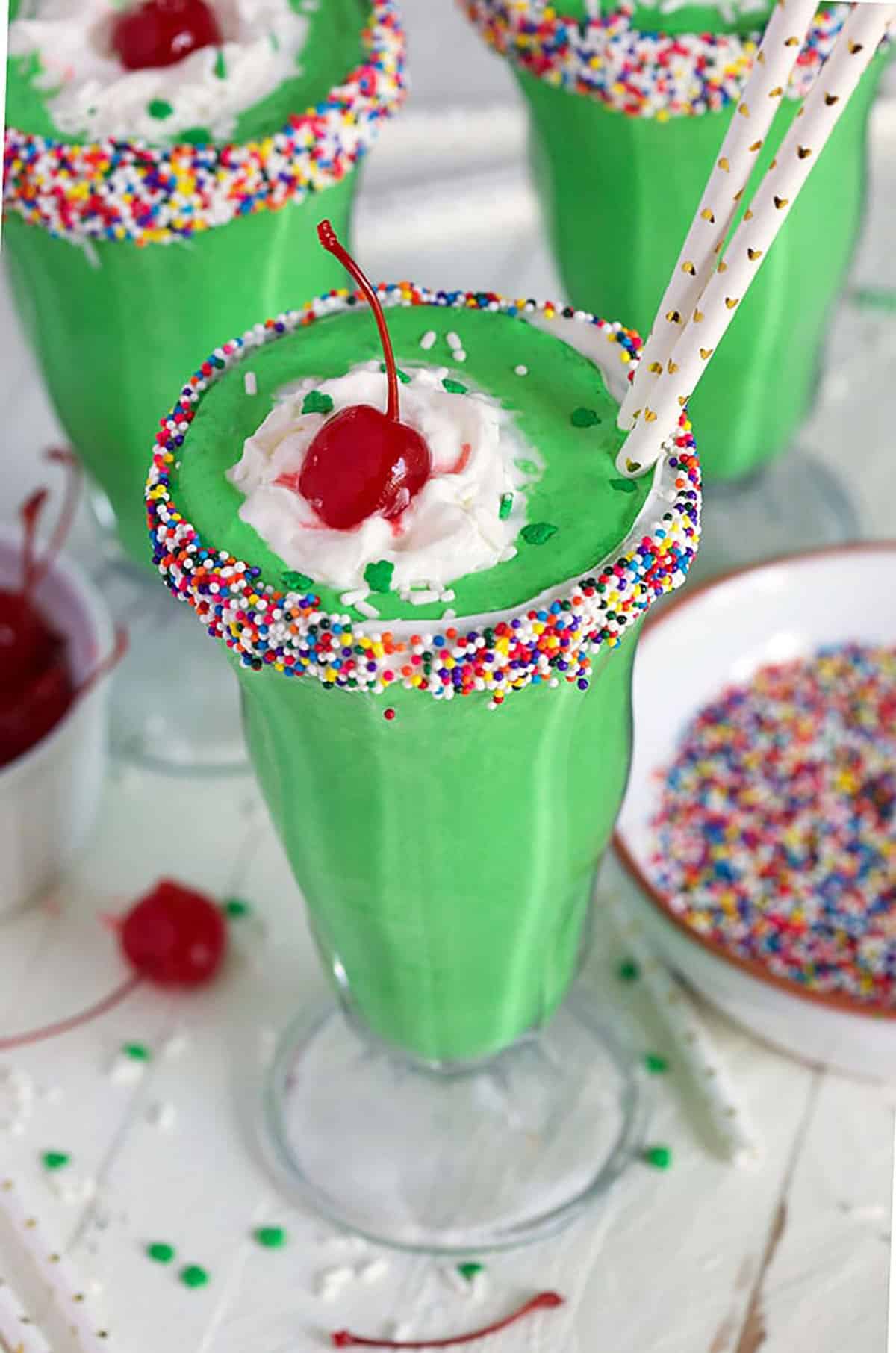 Overhead shot of shamrock shake in a glass with sprinkles on the rim.