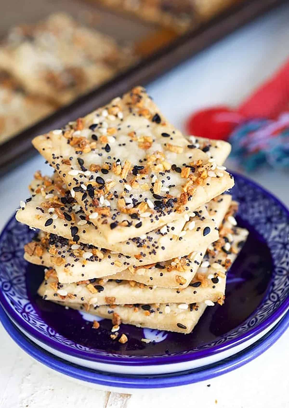 A stack of crackers is placed on a small navy blue plate.