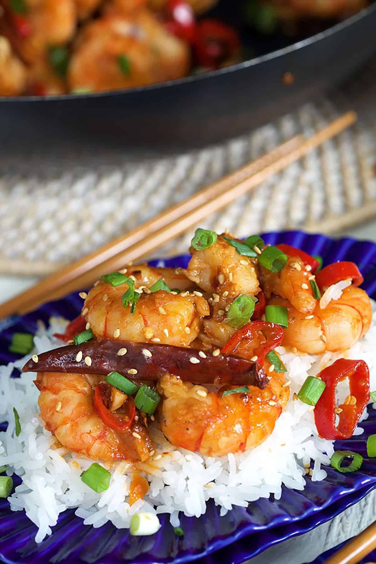 Shrimp is garnished with chopped green onions and sesame seeds.