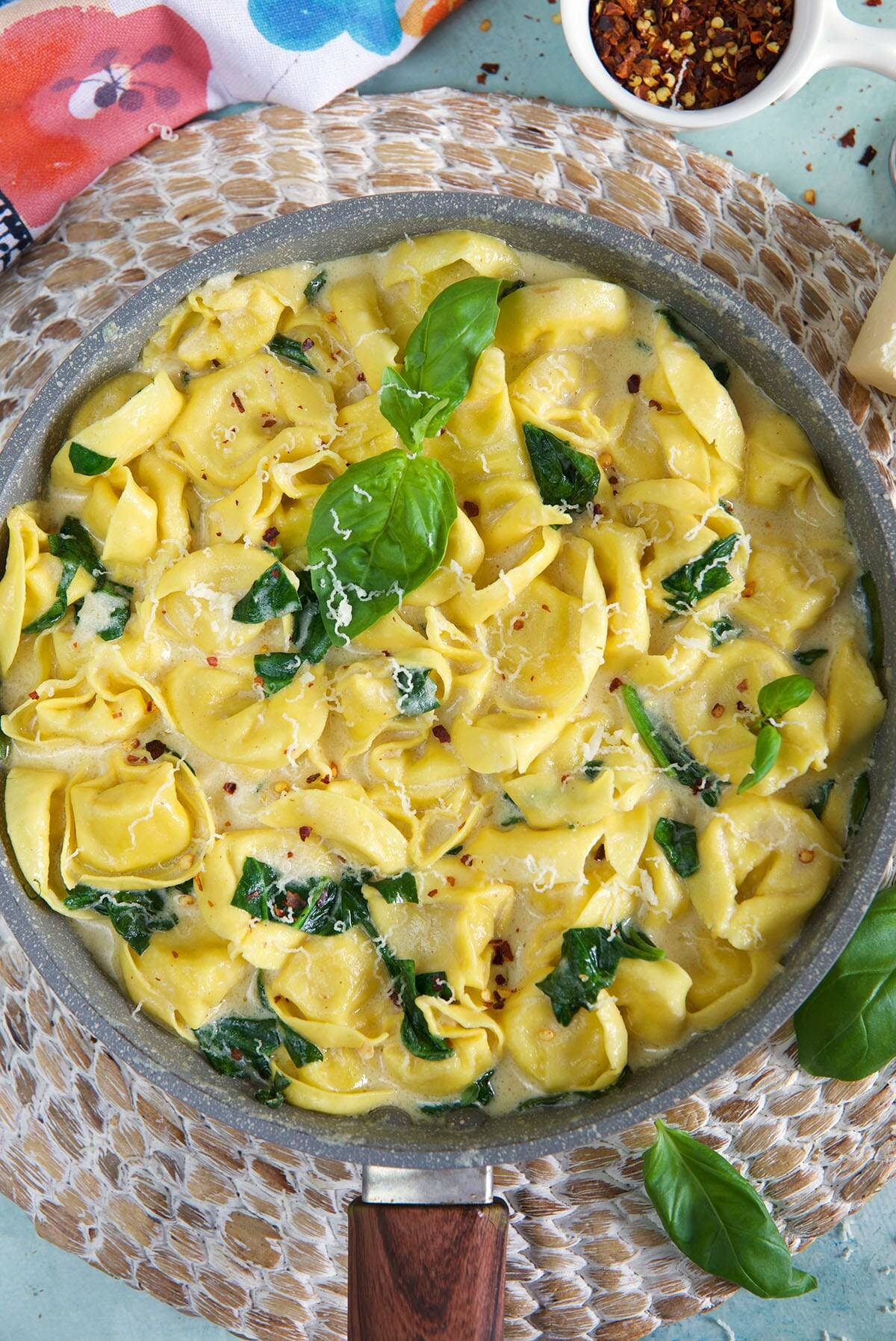 A saucepan is filled with cooked cheese tortellini. 
