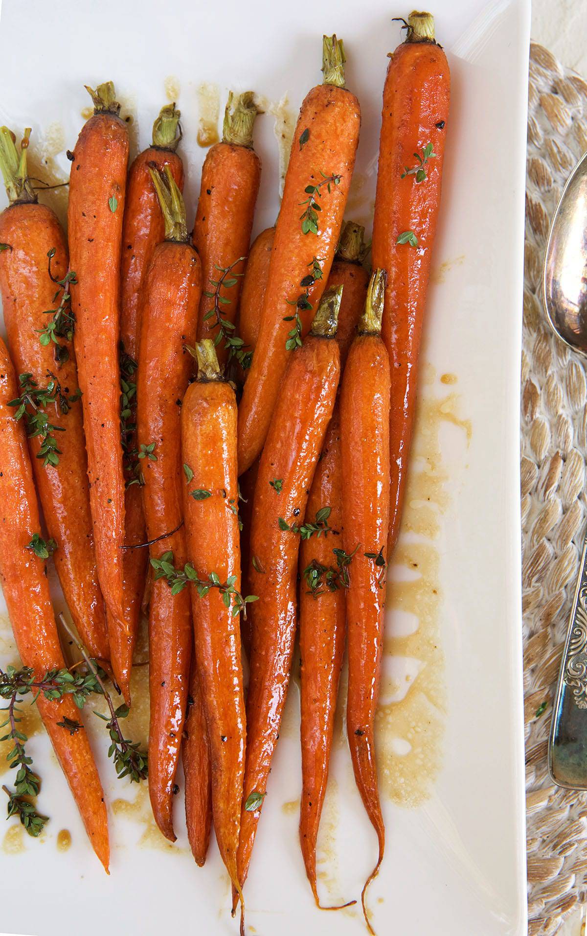 Roasted balsamic carrots are on a white platter, ready to be served. 