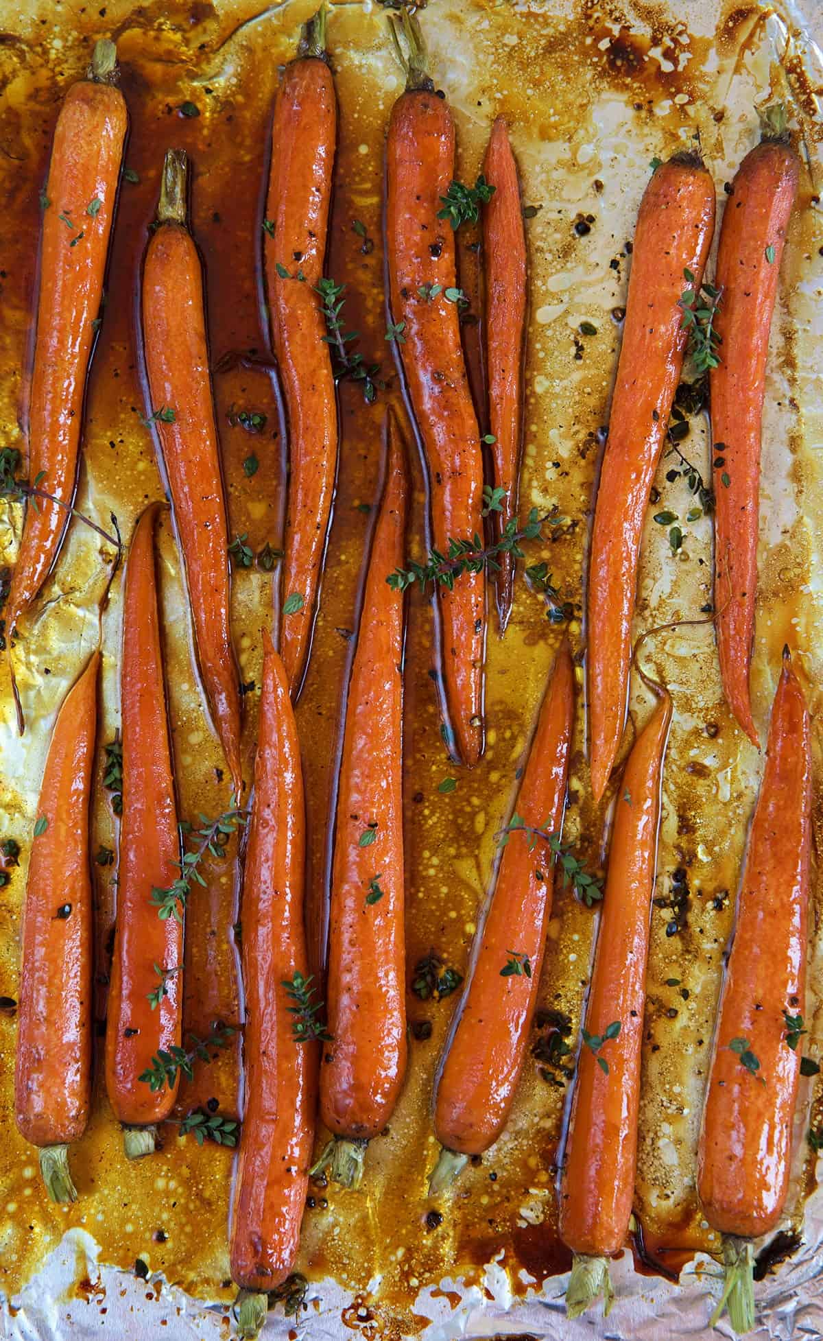 Carrots are spread out evenly on a baking sheet.