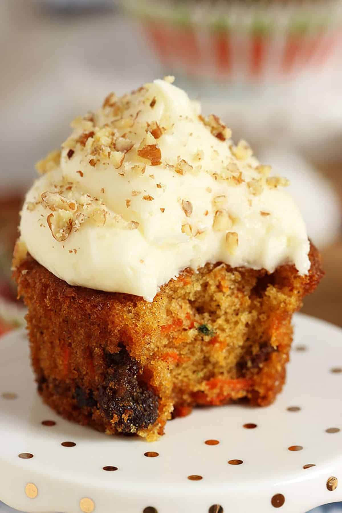 Carrot Cake Cupcake with cream cheese frosting and a bite taken out of it.