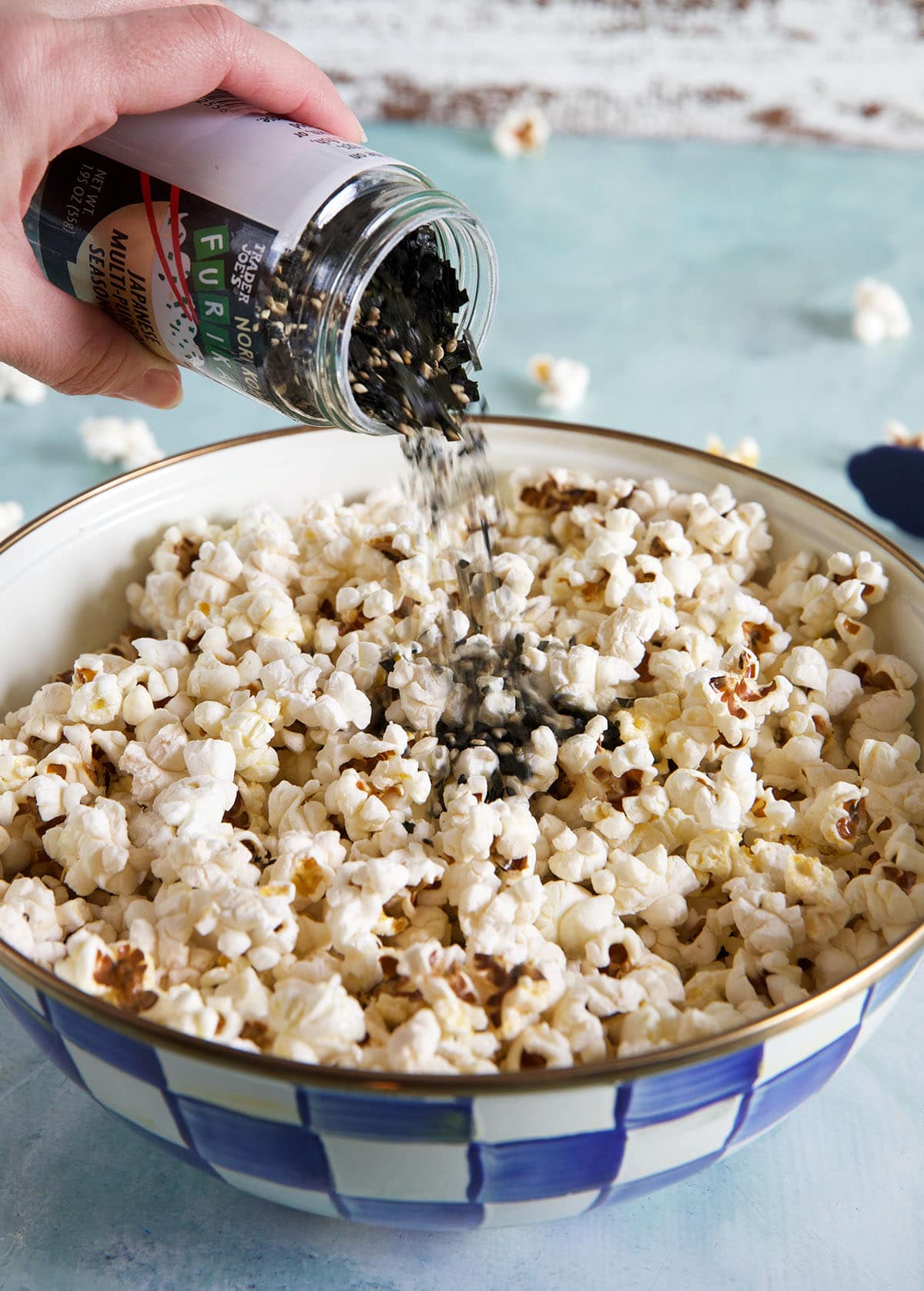 Furikake is being added to the buttery popcorn. 